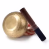 Hand-hammered Tibetan singing bowl with red cushion and wooden mallet for meditation and sound healing